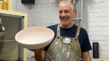 Picture of older man in apron holding large bowl
